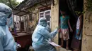 Petugas kesehatan India yang mengenakan alat pelindung diri melakukan pemeriksaan COVID-19 di kawasaan permukiman kumuh di tengah penyebaran wabah tersebut di Mumbai, India (17/6/2020). (Xinhua/Stringer)