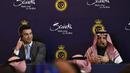Penyerang Portugal, Cristiano Ronaldo bersama Presiden Al-Nassr Musalli Al-Muammar mendengarkan laporan selama konferensi pers di Stadion Mrsool Park di Riyadh, Arab Saudi, Selasa (3/1/2023). Ronaldo, yang telah memenangkan lima penghargaan Ballon d'Ors sebagai pemain sepak bola terbaik di dunia dan lima gelar Liga Champions, akan bermain di luar Eropa untuk pertama kalinya dalam karirnya. (Photo by AFP)