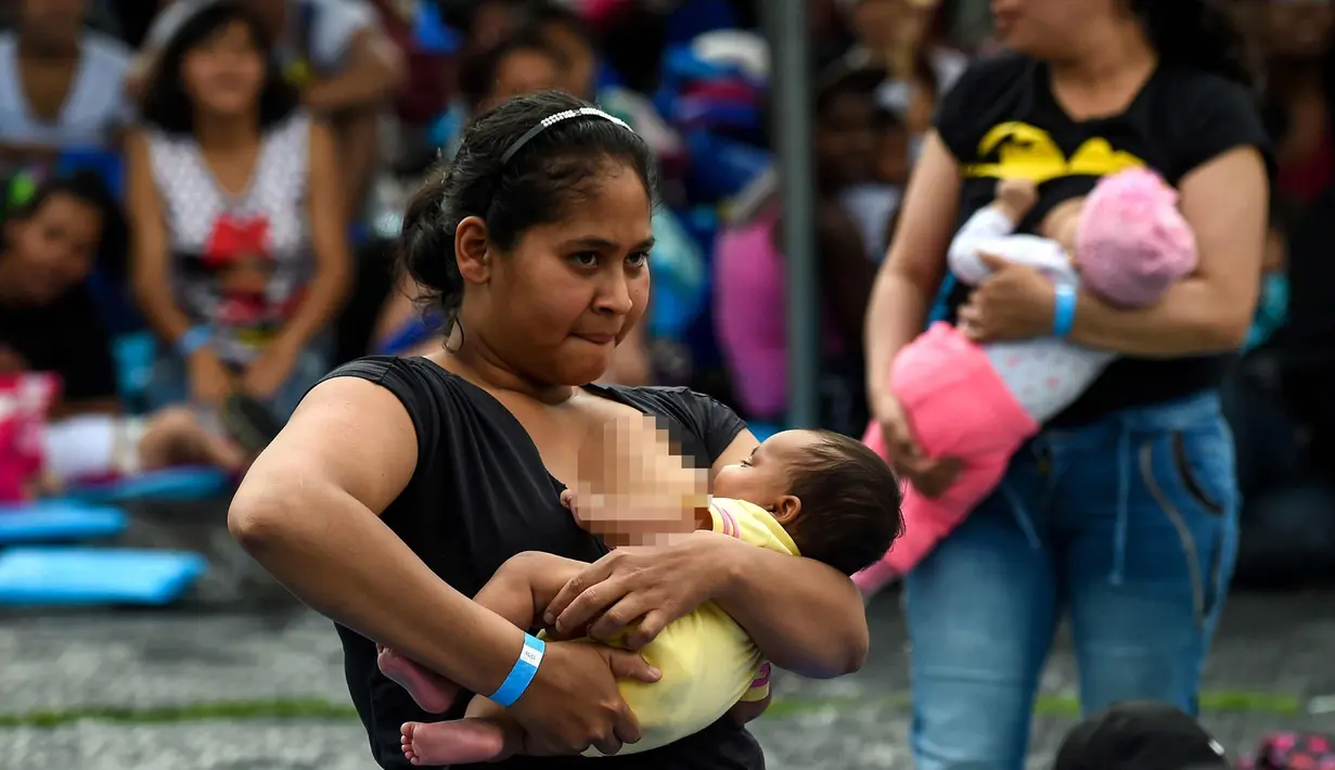 Seorang wanita menyusui bayinya saat mengikuti acara promosi manfaat menyusui, di sebuah taman di Bogota, Kolombia(3/11). Ratusan ibu menyusui bayi mereka untuk mempromosikan pemberian ASI sebagai bagian dari hak bayi. (AFP Photo/Raul Arboleda)