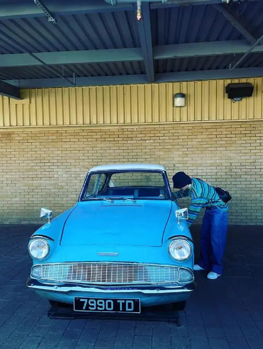 Jimin BTS berfoto dengan Flying Ford Anglia yang sangat ikonik. Jimin sepertinya sangat penasaran seperti apa interior mobil tersebut, hingga mengintipnya dari luar jendela mobil. (Foto: Instagram/ j.m)