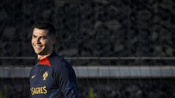 Pemain Portugal, Cristiano Ronaldo, tersenyum saat mengikuti sesi latihan jelang menghadapi laga Kualifikasi Euro 2024 di Lisbon, (20/3/2023). (AFP/Patricia De Melo Moreira)
