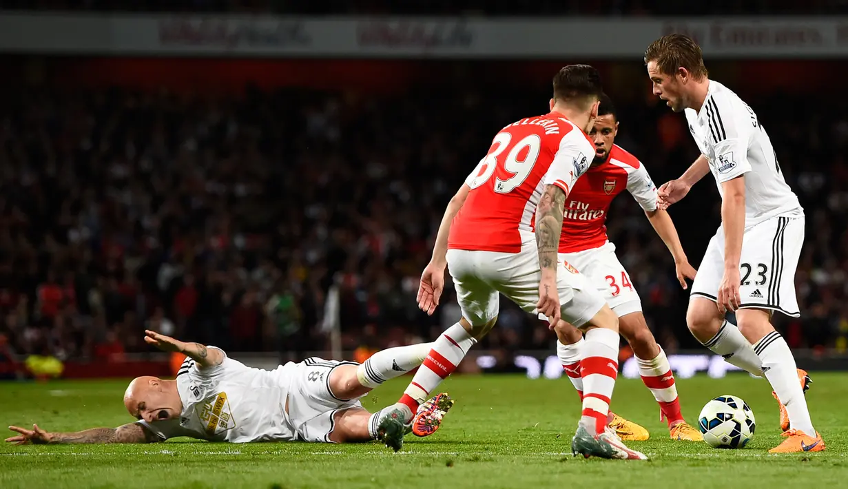 Gelandang Swansea City, Gylfi Sigurdsson (kanan) berusaha melewati dua pemain Arsenal saat Laga Liga Premier Inggris di Emirates Stadium, Selasa (12/5/2015). Swansea City menang 1-0 atas Arsenal. (Reuters/ADylan Martinez)