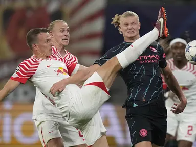 Penyerang Manchester City Erling Haaland berebut bola dengan bek RB Leipzig Lukas Klostermann pada laga matchday 2 Liga Champions 2023/2023 yang digelar di Red Bull Arena Leipzig, Kamis (5/10/2023) dini hari WIB. (AP Photo/Matthias Schrader)