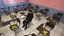 Seorang siswa duduk sendirian dalam kelas saat sekolah tatap muka di sekolah menengah Republic of Argentina di Iztacalco, Mexico City, Meksiko, Senin (30/8/2021). Jutaan anak Meksiko mulai menjalani sekolah tatap muka. (AP Photo/Marco Ugarte)