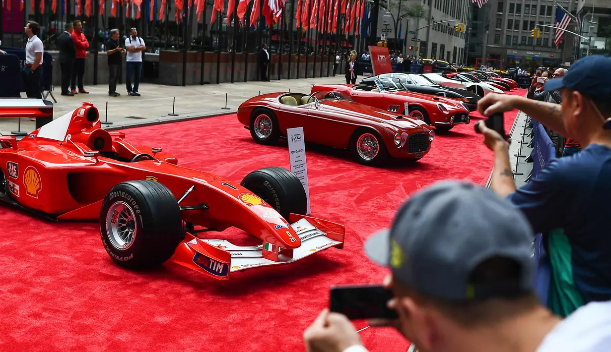 Pengunjung melihat mobil mantan pembalap Ferrari F1 dari Jerman, Michael Schumacher saat dipamerkan di perayaan ulang tahun Ferrari ke-70 di Rockefeller Plaza, New York, AS (8/10). (AFP Photo/Jewel Samad)