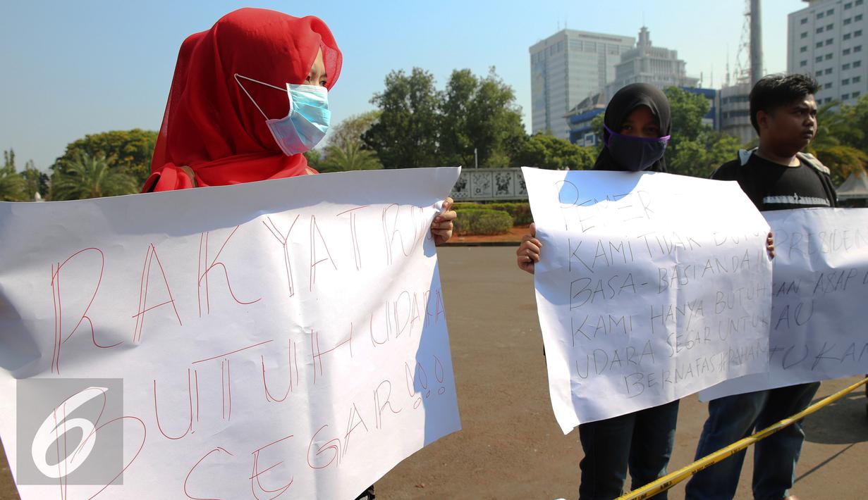 Mahasiswa Riau Jabodetabek membentangkan poster tuntutan saat unjuk rasa di depan Istana Merdeka, Jakarta, Jumat (18/9/2015). Dalam aksinya mereka mendesak pemerintah mencabut izin perusahan yang terlibat  dalam pembakaran. (Liputan6.com/Faizal Fanani)