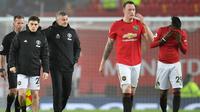 Manajer Manchester United, Ole Gunnar Solskjaer bersama timnya, Daniel James, Phil Jones dan Aaron Wan-Bissaka meninggalkan lapangan setelah laga lanjutan Liga Inggris kontra Burnley di Old Trafford, Rabu (23/1/2020). MU tidak berdaya di kandang sendiri usai takluk 0-2 dari Burnley. (Paul ELLIS/AFP)