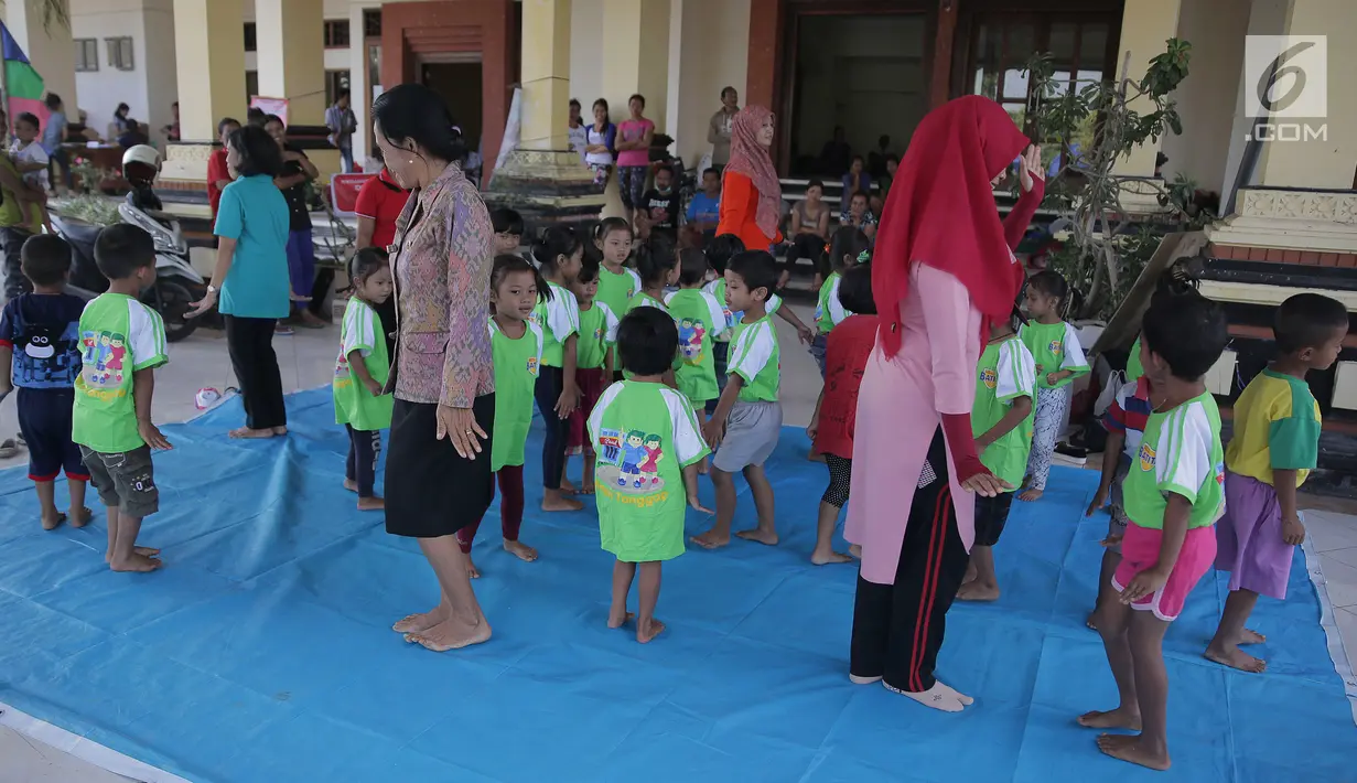 Anak-anak TK menari di kamp pengungsian Gor Swace Pura, Klungkung, Bali, Kamis (28/09). Kegiatan tersebut bertujuan menghilangkan rasa trauma serta sebagai sarana bermain anak korban bencana alam. (Liputan6.com/Gempur M Surya)