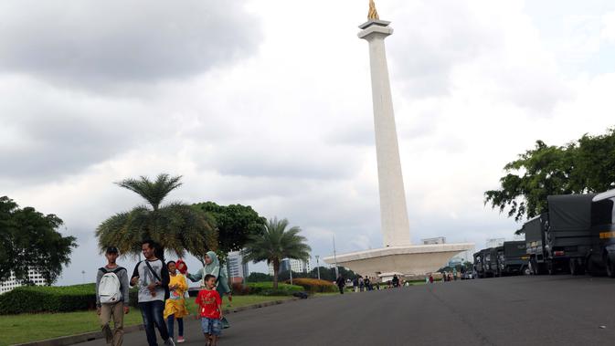Warga berjalan-jalan di kawasan Monumen Nasional, Jakarta, Jumat (19/4). Libur panjang perayaan Paskah 2019 dimanfaatkan warga untuk berwisata di kawasan Monumen Nasional. (Liputan6.com/Helmi Fithriansyah)