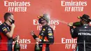 Pembalap Mercedes Lewis Hamilton (kanan) menyemprotkan sampanye ke pembalap Red Bull Max Verstappen yang memenangkan 70th Anniversary Formula 1 Grand Prix di Sirkuit Silverstone, Silverstone, Inggris, Minggu (9/8/2020). Max Verstappen tercepat di F1 GP Silverstone 2020. (Andrew Boyers, Pool via AP)