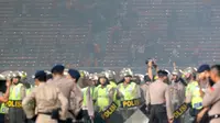 Polisi berjaga didalam lapangan saat terjadi bentrok dengan suporter The Jak pada laga Torabika SC 2016 antara Persija vs Sriwijaya FC di Stadion Utama Gelora Bung Karno, Jakarta (24/6/2016). (Bola.com/Nicklas Hanoatubun)