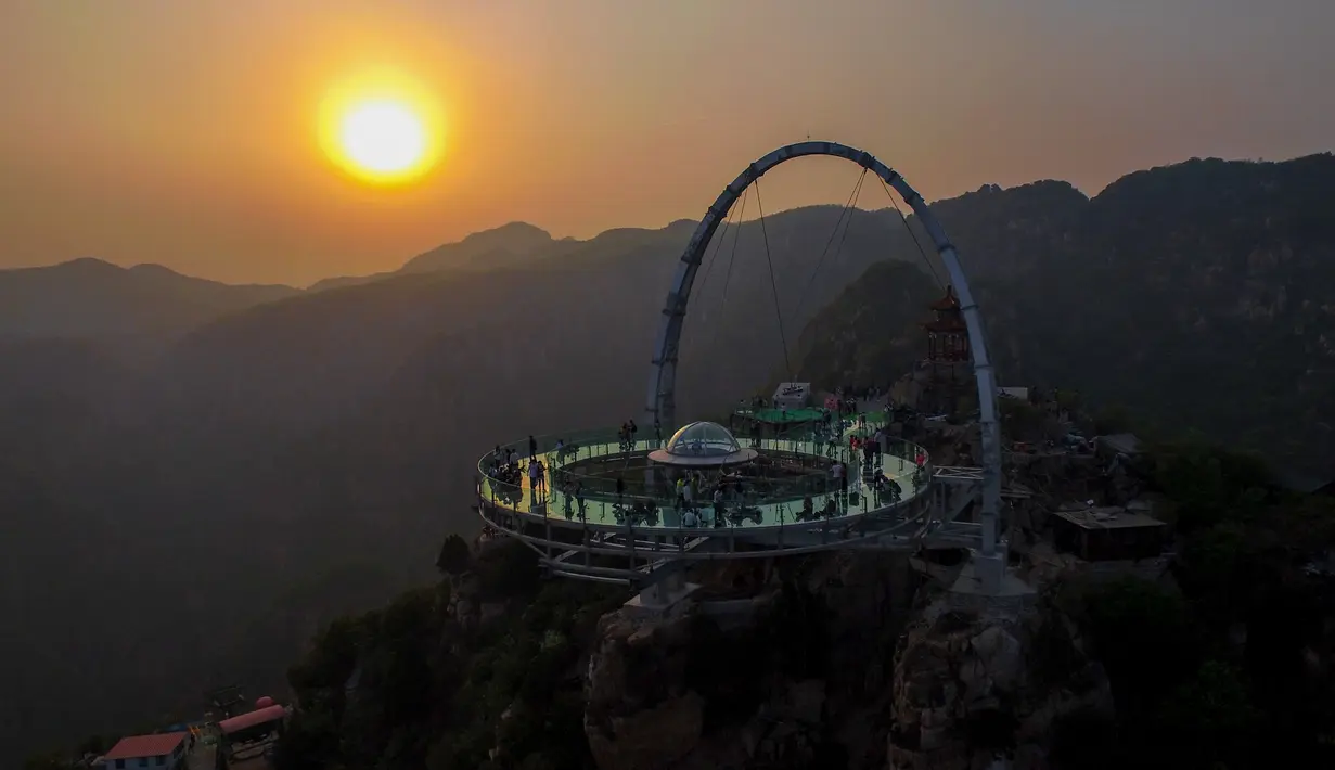 Sebuah panggung berlantai kaca berada di tempat wisata yang berada di pinggir tebing di Shilinxia, Beijing, 30 april 2016. Panggung kaca yang menggantung hingga 32.8 meter dari tepi tebing ini merupakan objek wisata baru di China. (AFP PHOTO/STR)