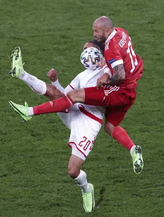 Pemain Denmark Yussuf Poulsen (kiri)  berebut bola dengan pemain Rusia Fyodor Kudryashov pada pertandingan Grup B Euro 2020 di Stadion Parken, Kopenhagen, Denmark, Senin (21/6/2021). Denmark menang 4-1. (AP Photo/Hannah McKay, Pool)
