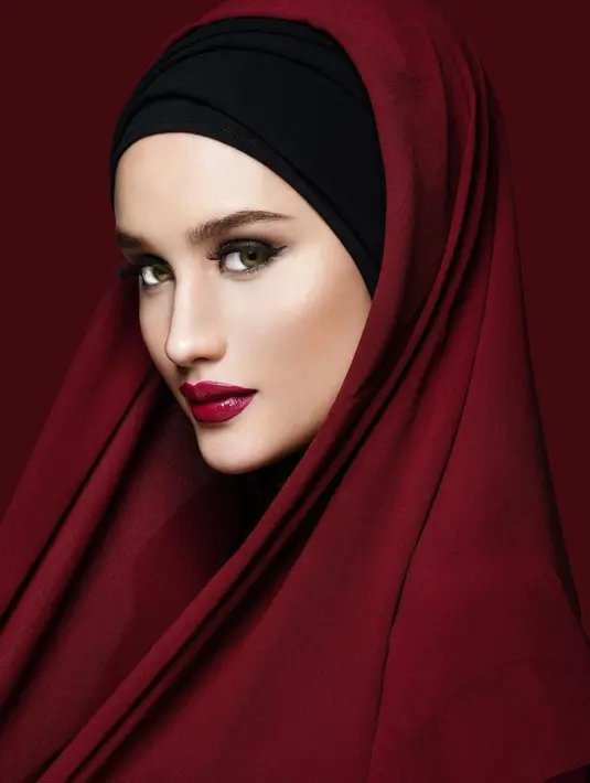 Potret santun Cinta Laura kenakan hijab berwarna merah bata. Penampilannya semakin luar biasa dengan inner hitam, yang kemudian ditumpuk dengan kain panjang berwarna merah. [Foto: Instagram/claurakiehl]