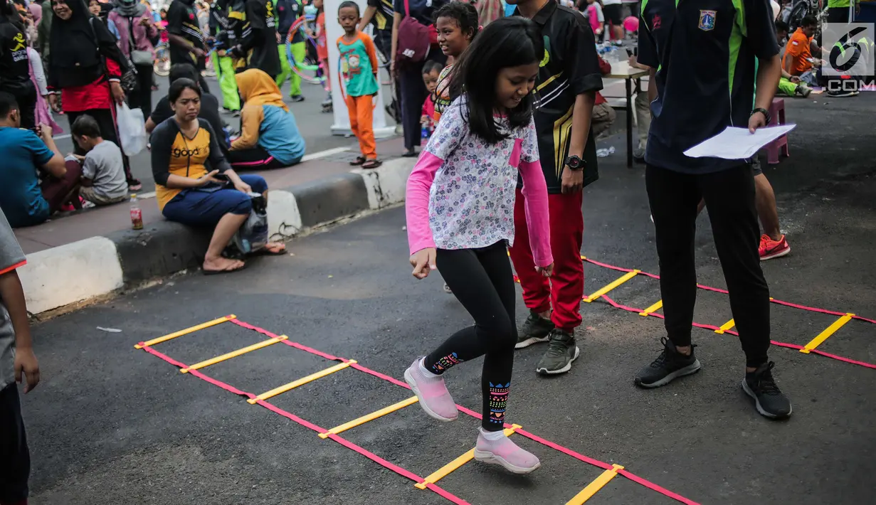 Anak-anak bermain permainan tradisional gobak sodor ditemani sejumlah mahasiswa dari Penggerak Olahraga saat car free day (CFD) di kawasan Bundaran HI, Jakarta, Minggu (14/7/2019). Kegiatan yang rutin digelar ini untuk mengajak masyarakat DKI Jakarta aktif berolahraga. (Liputan6.com/Faizal Fanani)