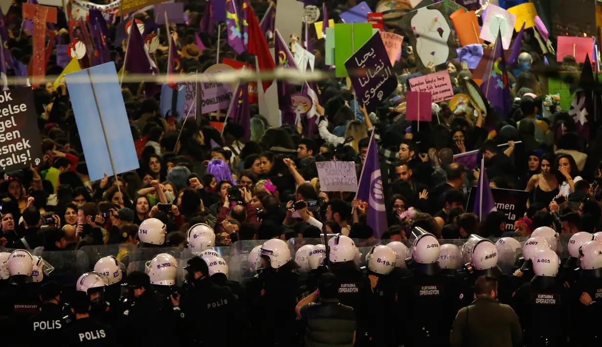 Polisi menghalau pengunjuk rasa yang ingin menggelar pawai untuk memperingati Hari Perempuan Internasional di Istanbul, Turki, Jumat (8/3). Polisi menembakkan gas air mata untuk membubarkan pengunjuk rasa. (AP Photo/Lefteris Pitarakis)