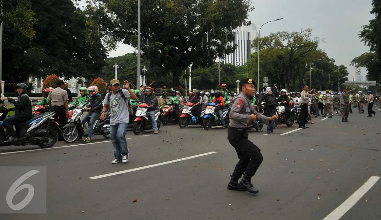 Pengemudi ojek online dilempari batu oleh sopir taksi yang melakukan unjuk rasa di depan Istana Negara, Jakarta, Selasa (22/3). Aksi itu pecah saat pengunjuk rasa mendapat ejekan dari pengemudi ojek online. (Liputan6.com/Gempur M Surya)