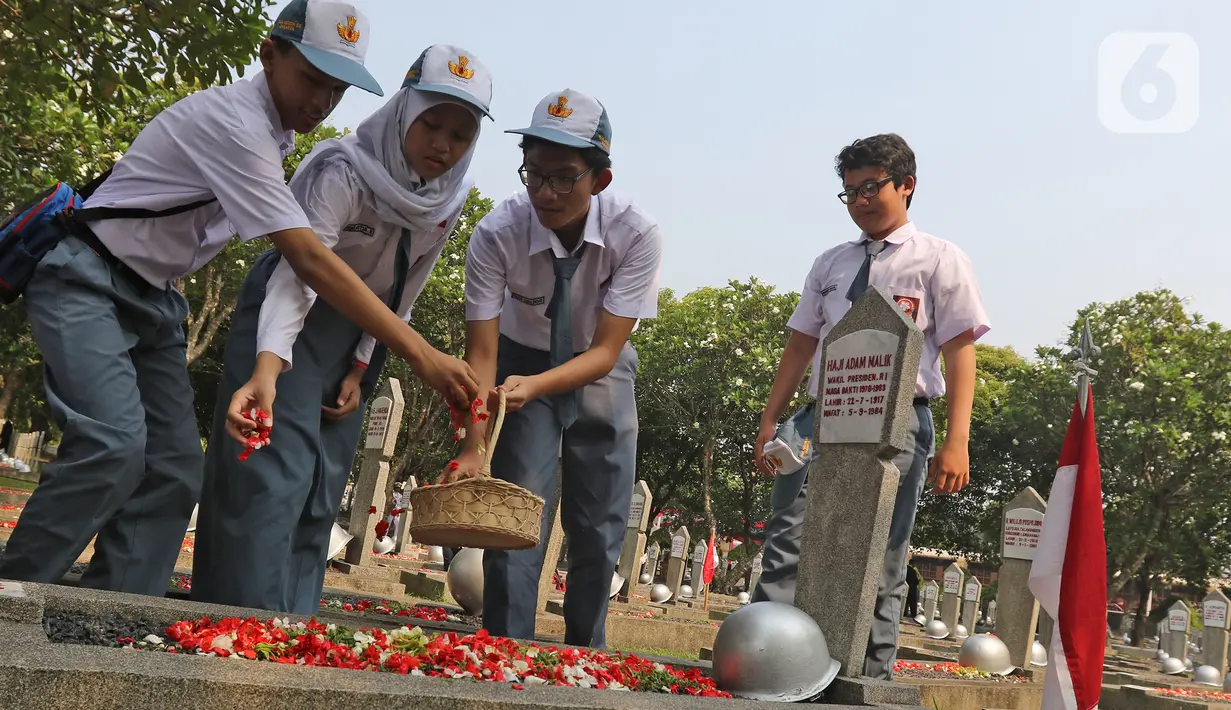 Sejumlah pelajar melakukan tabur bunga saat peringatan Hari Pahlawan Nasional di Taman Makam Pahlawan (TMP) Utama Kalibata, Jakarta Selatan, Minggu (10/11/2109). Ziarah tersebut digelar dalam rangka peringatan Hari Pahlawan 10 November 2019. (Liputan6.com/Herman Zakharia)