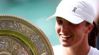 Petenis Polandia, Iga Swiatek, merayakan kemenangannya dengan trofi Venus Rosewater Dish setelah mengalahkan petenis AS Amanda Anisimova dalam pertandingan final tunggal putri pada hari&nbsp;ke-13 Kejuaraan Wimbledon 2025 di All England Lawn Tennis and Croquet Club di Wimbledon, London barat daya, pada 12 Juli 2025. (HENRY NICHOLLS /AFP)