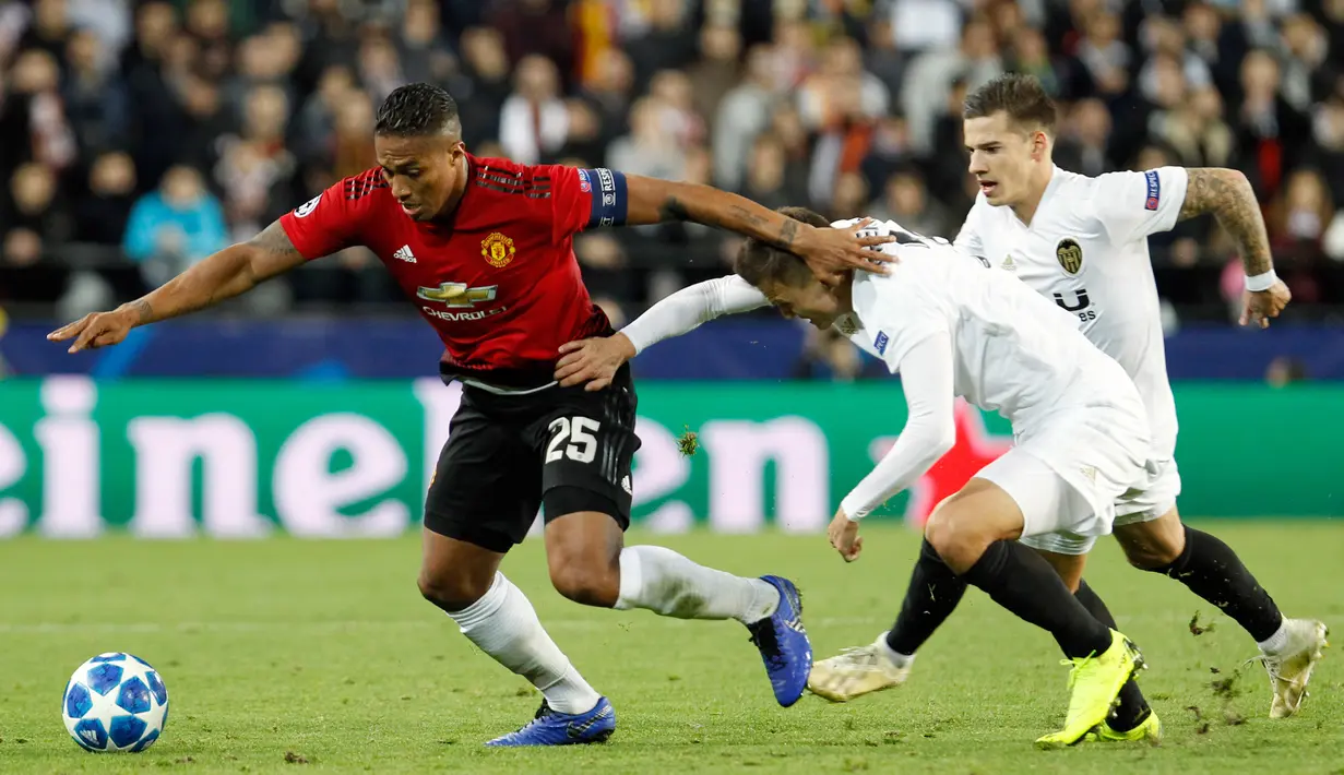 Pemain Manchester United (MU), Antonio Valencia (kiri) menggiring bola melewati pemain Valencia pada babak penyisihan Grup H Liga Champions di Stadion Mestalla, Valencia, Spanyol, Rabu (12/12). MU kalah 1-2 atas Valencia. (AP Photo/Alberto Saiz)