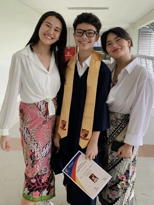 Hadir di wisuda sanga adik, keduanya tampil kompak dengan atasan putih lengan panjang dipadukan bawahan kain batiknya.  [@zahwamassaid/@aaliyah.massaid]