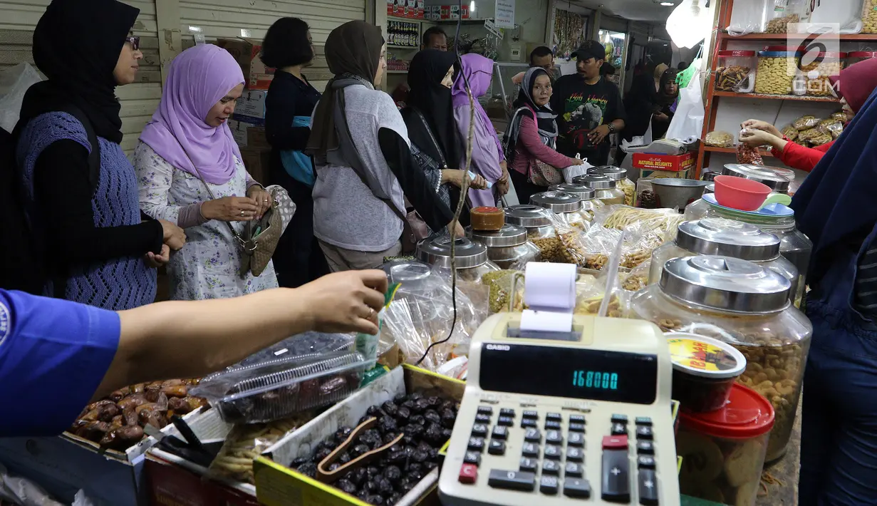 Sejumlah pembeli memilih kue kering di Pasar Mayestik, Jakarta Selatan, Senin (11/6). Separuh Ramadan dan jelang lebaran masyarakat mulai berburu kue kering. (Liputan6.com/Johan Tallo)