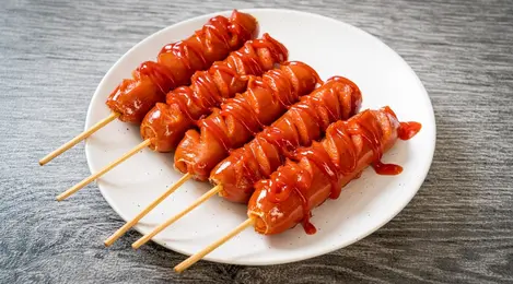 Sosis panggang gurih dengan aroma smokey khas, disajikan hangat bersama sayuran panggang dan saus sambal
