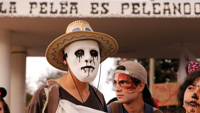 Mahasiswa mengenakan kostum halloween saat menggelar aksi protes menuntut peningkatan anggaran pendidikan di Bogota, Kolombia, Rabu (31/10). (AP Photo/Fernando Vergara)