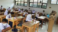Siswa SMP Negeri 1 Depok mulai mengikuti pelaksanaan PTM Terbatas, Senin (4/10/2021). (Liputan6.com/Dicky Agung Prihanto)