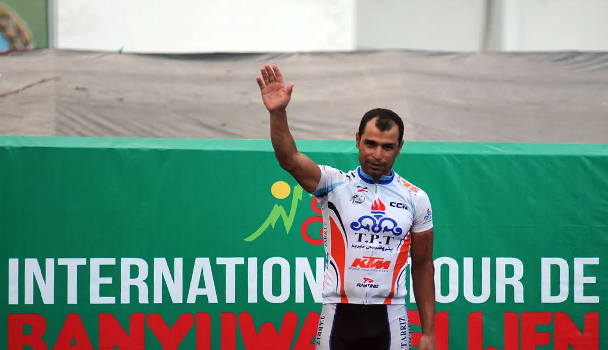 Mehdi Sohrabi dari Tabriz Petrochemical Team mengangkat tangan sesaat sebelum penyerahan piala pemenang etape keempat Internasional Tour De Banyuwangi Ijen,  (19/10/2014).  (Liputan6.com/Helmi Fithriansyah) 