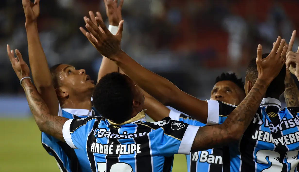 Para pemain Gremio merayakan gol yang dicetak Andre Felipe ke gawang Libertad pada laga Copa Libertadores di Stadion Defensores del Chaco, Asuncion, Kamis (1/8). Gremio lolos ke babak perempat final. (AFP/Norberto Duarte)