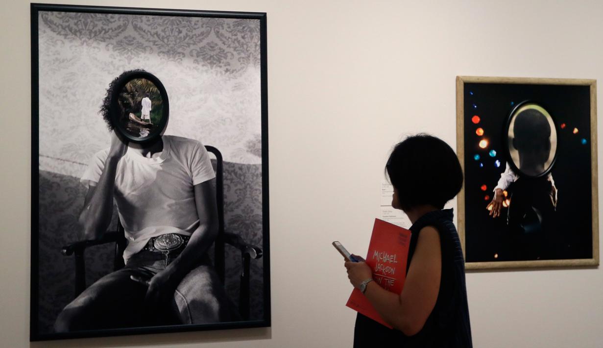 Seorang wanita mengamati karya seni Todd Gray pada pameran 'Michael Jackson: On The Wall' di National Potrait Gallery, London, Rabu (27/6). Dalam pameran ini, karya-karya yang dihasilkan lebih dari 40 seniman dipamerkan. (AP/Kirsty Wigglesworth)