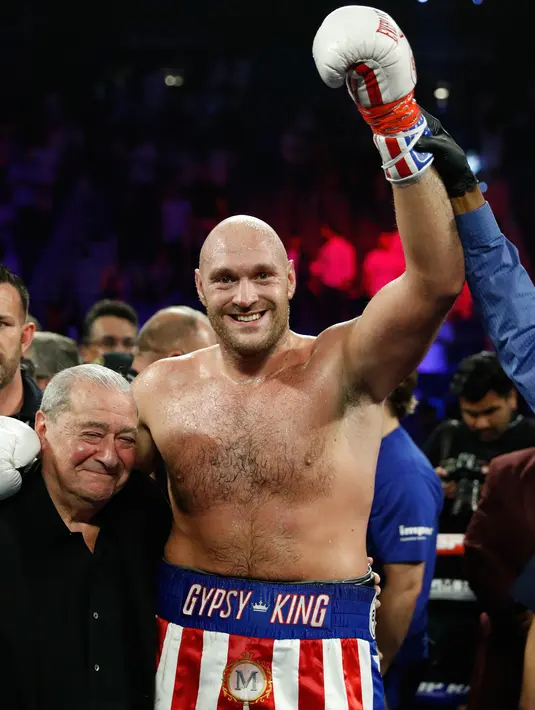 Petinju Inggris Tyson Fury tersenyum usai mengalahkan petinju petinju Jerman Tom Schwarz dalam pertarungan tinju kelas berat di MGM Grand Arena, Las Vegas, AS (16/6/2019). Tyson Fury meraih kemenangan secara technical knock out (TKO) atas Tom Schwarz. (AP Photo/John Locher)