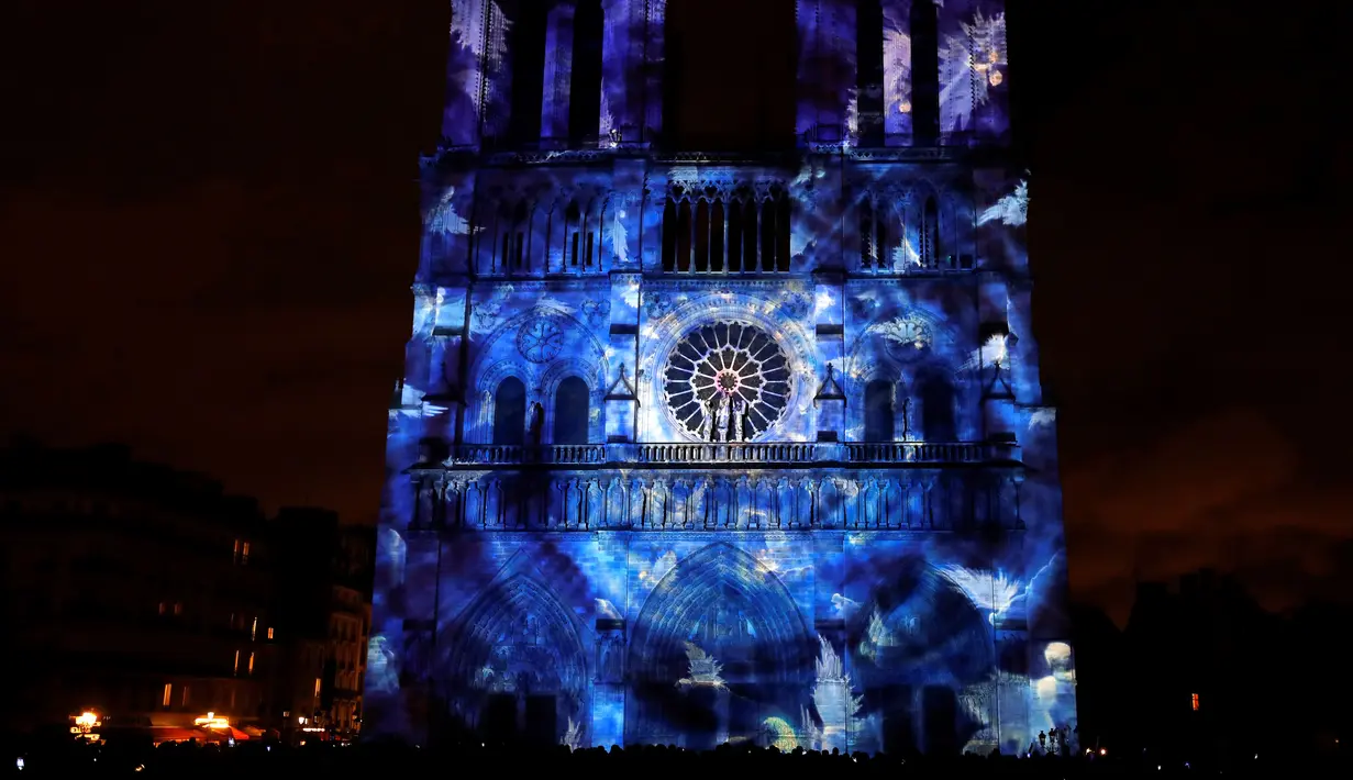 Pemandangan saat Gereja Katedral Notre-Dame de Paris dihiasi cahaya, Prancis (11/11). Pertunjukan cahaya ini dalam rangka peringatan Hari Gencatan Senjata yang menandai berakhirnya Perang Dunia I. (AFP Photo/Francois Guillot)