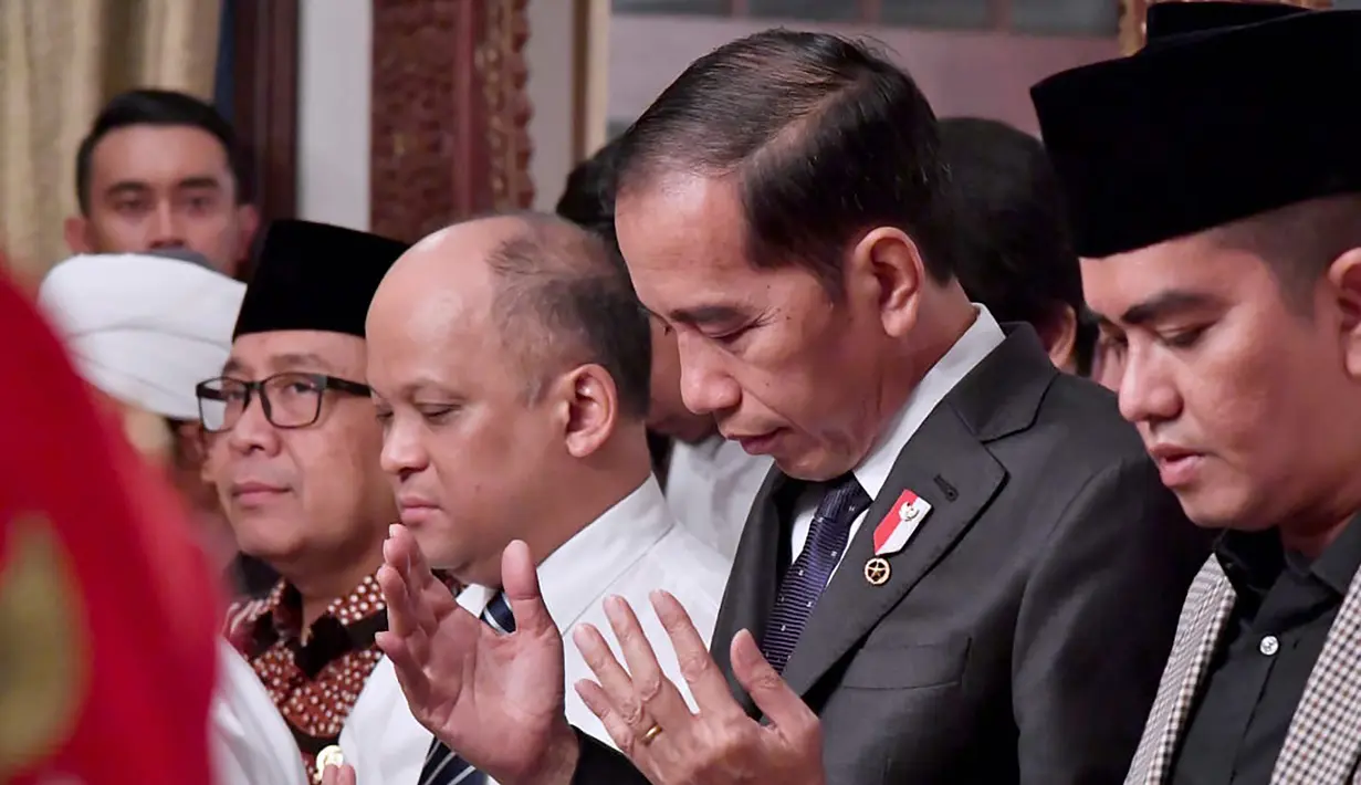 Presiden Joko Widodo atau Jokowi memanjatkan doa untuk Presiden ke-3 RI BJ Habibie saat melayat ke rumah duka di Patra Kuningan, Jakarta, Kamis (12/9/2019). Jokowi akan memimpin upacara pemakaman Habibie di TMP Kalibata. (Handout/Indonesian Presidential Palace/AFP)