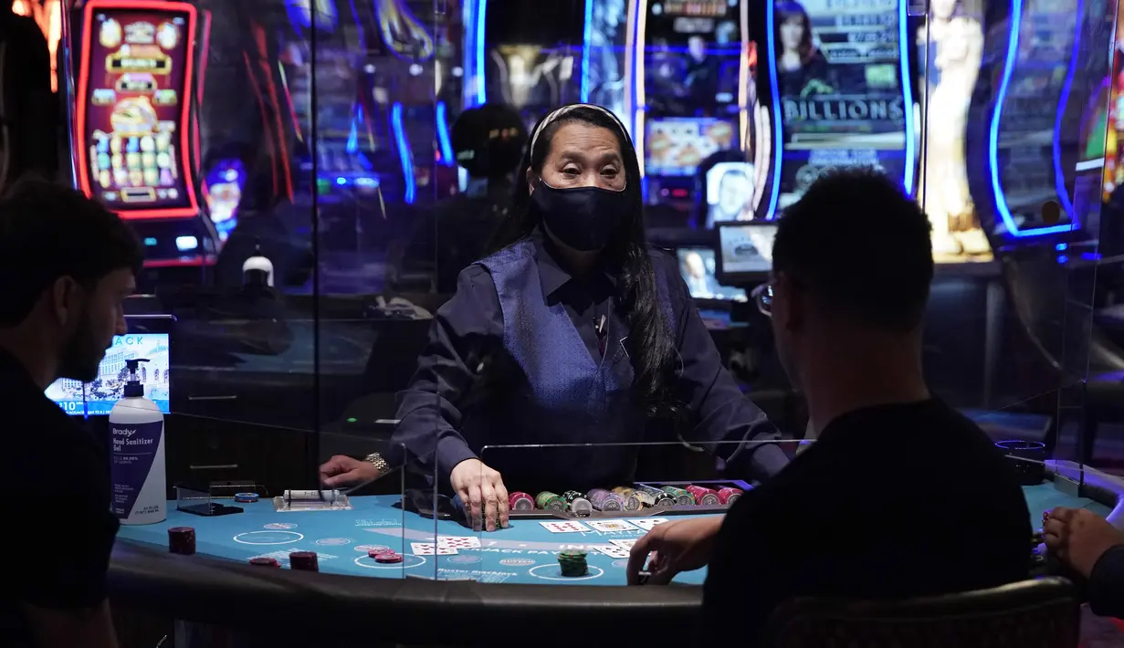 Para pengunjung bermain blackjack saat pembukaan kembali hotel dan kasino Bellagio di Las Vegas, Nevada, Amerika Serikat, Kamis (4/6/2020). Kasino di Nevada diizinkan kembali beroperasi setelah penutupan sementara untuk mencegah penyebaran virus corona COVID-19. (AP Photo/John Locher)