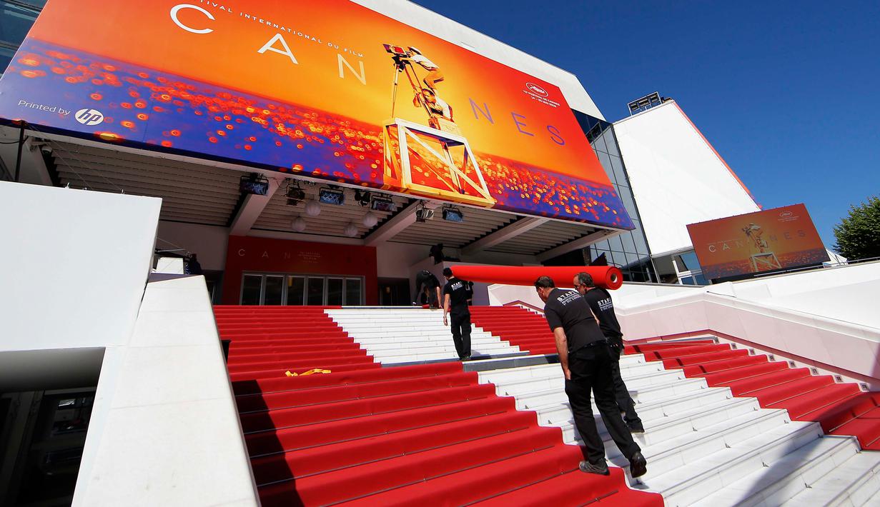 Pekerja memasang karpet merah di depan pintu masuk utama jelang upacara pembukaan Festival Film Cannes 2019 di Cannes, Prancis, Selasa (14/5/2019). Festival Film Cannes merupakan ajang paling bergengsi di dunia perfilman. (REUTERS/Regis Duvignau)