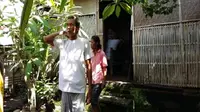 I Gusti Ngurah Wijaya bersama sang istri setelah menunjukkan tembok rumahnya yang bolong dan sering dimasuki ular. (Dewa Ayu Pitri Arisanti/Radar Bali)