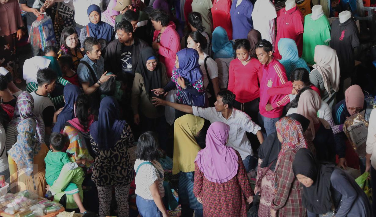 Sejumlah pembeli mencari berbagai kebutuhan berupa pakaian di Pasar Tanah Abang, Jakarta, Rabu (9/12). Libur pilkada dimanfaatkan warga untuk berbelanja pakaian di pasar tekstil terbesar di Asia Tenggara itu. (Liputan6.com/Angga Yuniar)