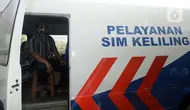 Warga duduk dalam mobil saat mengurus SIM di Pelayanan SIM Keliling, Tangerang Selatan, Banten, Jumat (7/8/2020). Ditlantas Polda Metro Jaya memberi dispensasi bagi pemilik SIM yang masa berlakunya habis di masa pandemi COVID-19 bisa memperpanjang sampai akhir Agustus 2020. (merdeka.com/Dwi Narwoko)