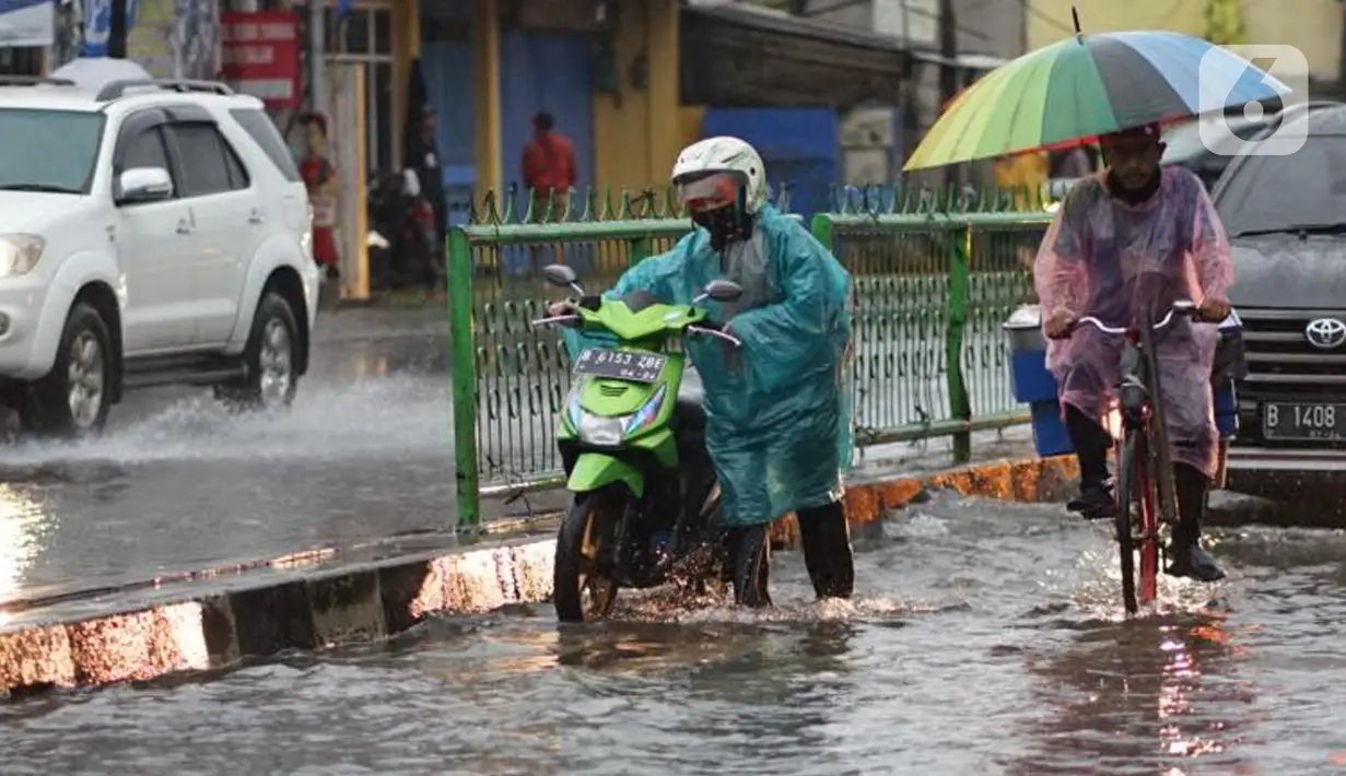 Pengendara mendorong motornya menerobos banjir yang menggenangi Jalan Arif Rahman Hakim di Depok, Jawa Barat, Senin (18/5/2020). Sistem drainase buruk menjadi penyebab utama kawasan tersebut selalu tergenang banjir setiap hujan deras. (Liputan6.com/Immanuel Antonius)