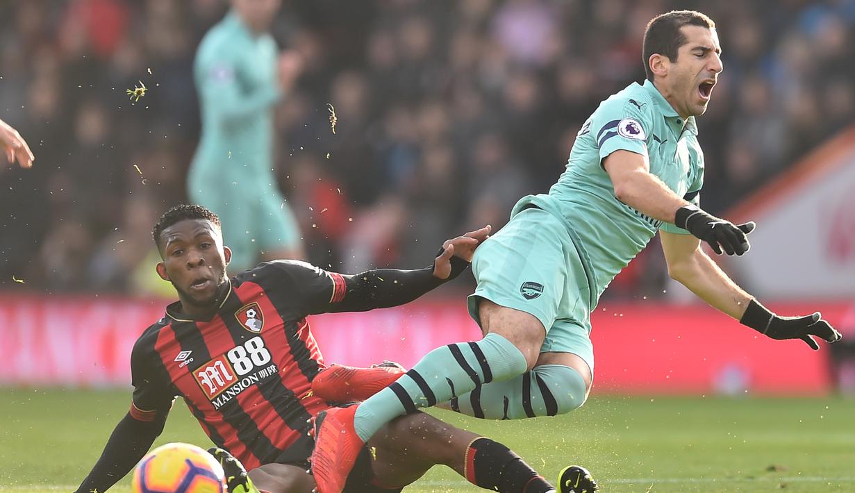 Gelandang Arsenal Henrikh Mkhitaryan saat dijegal Jeferrson Lerma pada laga lanjutan Premier League yang berlangsung di stadion Dean Court, Inggris, Minggu (25/11).  Arsenal menang 2-1. (AFP/Glyn Kirk)