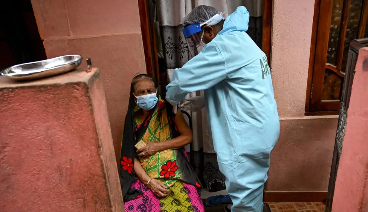 Seorang petugas kesehatan tentara (kanan) menyuntik seorang wanita dengan dosis virus corona COVID-19 saat vaksinasi keliling di Kolombo Sri Lanka, Kamis (12/8/2021). (Ishara S. KODIKARA/AFP)
