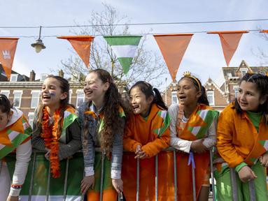 Reaksi anak-anak saat menunggu kedatangan Raja Belanda Willem-Alexander, Ratu Maxima, Putri Amalia dan Putri Ariane saat perayaan Hari Raja di Rotterdam, pada 27 April 2023. (Robin van Lonkhuijsen/ANP/AFP)