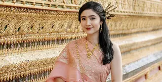 Ia mengenakan pakaian tradisional Thailand yang disebut dengan chut thai. Febby mengenakan chut thai atasan pink dipadukan bawahan mirip songket warna coklat. [Instagram/@febbyrastanty]