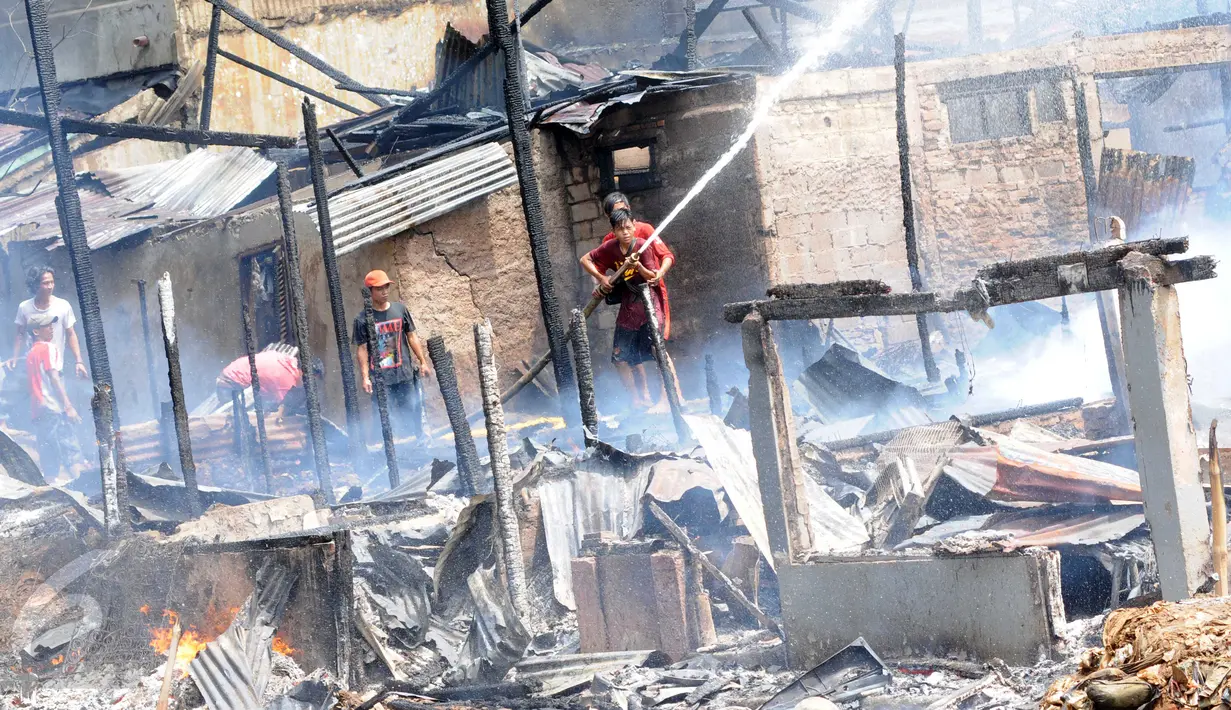 Warga mencoba memadamkan api saat kebakaran di kawasan padat penduduk Bukit Duri, Jakarta, Kamis (24/12). Kebakaran yang menghanguskan sekitar 70 petak rumah itu masih dalam penyelidikan pihak terkait. (Liputan6.com/Helmi Afandi)