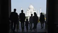 Siluet PM Kanada Justin Trudeau bersama sang istri, Sophie Gregoire Trudeau serta tiga anaknya saat memandangi Taj Mahal di Agra, India, Minggu (18/2). PM Kanada mengajak keluarganya ke Taj Mahal di sela-sela kunjungan ke India. (MONEY SHARMA/AFP)