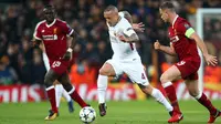 Pemain AS Roma,  Radja Nainggolan mengendalikan bola dikawal pemain Liverpool, Jordan Henderson pada laga leg pertama semifinal Liga Champions 2017-2018 di Anfield, Selasa (24/4). AS Roma kalah telak dengan skor 2-5 dari Liverpool. (AP/Dave Thompson)