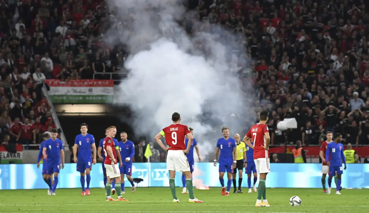Para pemain menunggu setelah suar dilemparkan ke lapangan usai gol ketiga Inggris ke gawang Hungaria pada pertandingan sepak bola Grup I kualifikasi Piala Dunia 2022 di Puskas Ferenc Arena, Budapest, Hungaria, Kamis (2/9/2021). Inggris menang 4-0. (Tibor Illyes/MTI via AP)