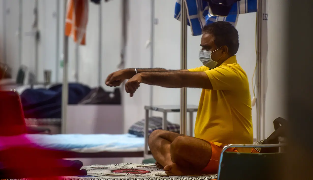 Pasien melakukan yoga di dalam bangsal di kompleks olahraga Commonwealth Games (CWG) Village yang sementara diubah menjadi pusat perawatan Covid-19 di New Delhi, India, Kamis (16/7/2020). Kasus virus corona (Covid-19) di India hampir menyentuh angka 1 juta orang.  (Money SHARMA / AFP)